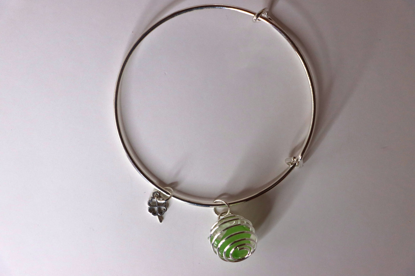 Green cage bracelet with silver shamrock