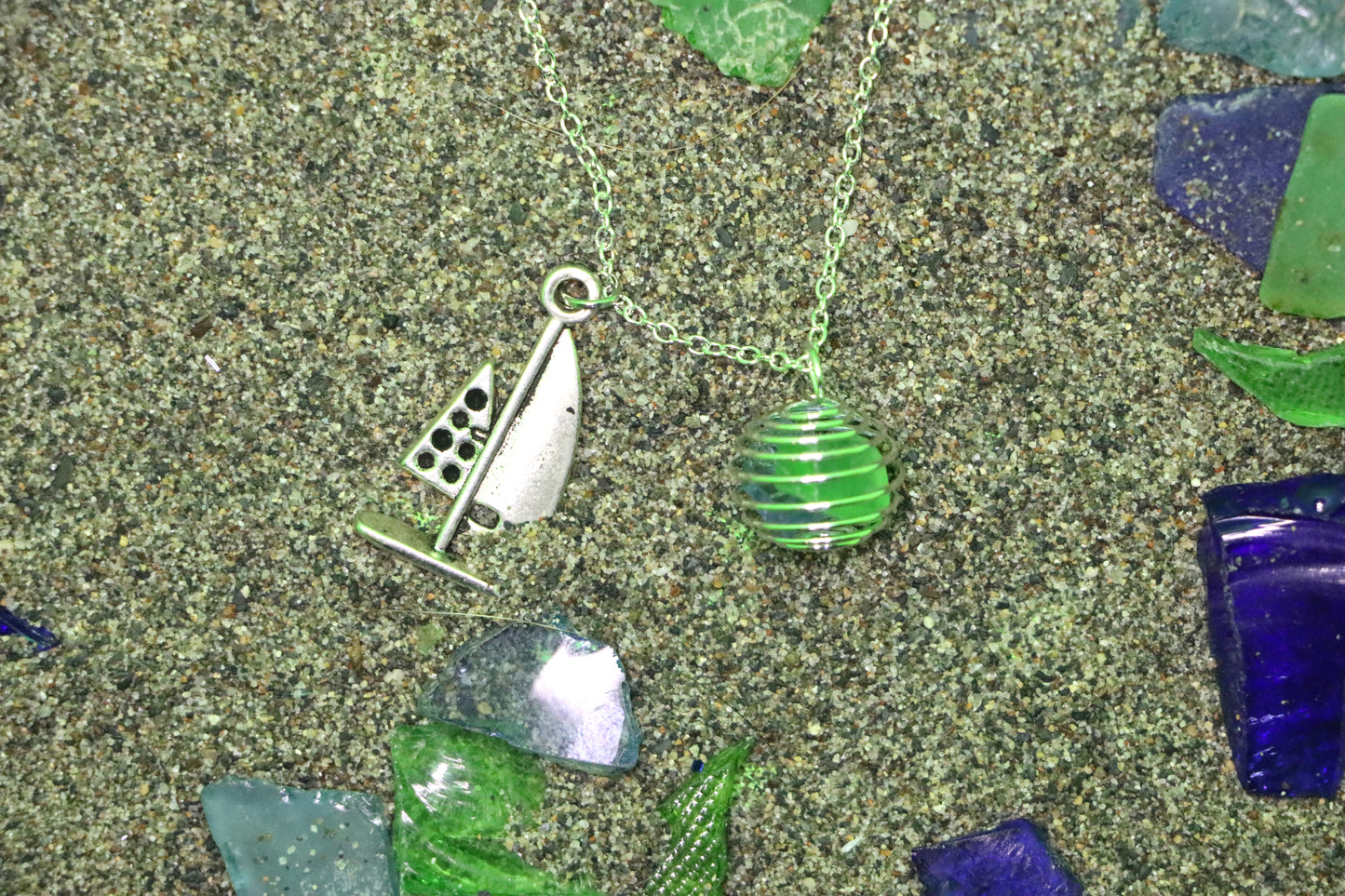 Green and blue cage with sailboat necklace